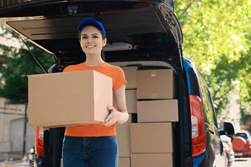 Canvas Print - Courier holding package near delivery truck outdoors