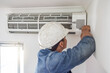 © Lumeez/peopleimages.com - Air conditioner, ac repair and building hvac maintenance of a handyman and builder on home renovation. Electric technician, service worker and contractor in a house for equipment installation on wall