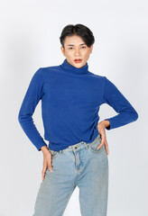 Wall Mural - Portrait isolated cutout studio closeup shot Asian young sexy slim fashionable LGBTQ gay male fashion model in turtleneck long sleeve shirt jeans standing posing look at camera on white background