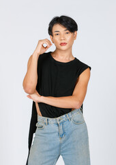 Wall Mural - Portrait isolated cutout studio closeup shot Asian young sexy cheerful slim fashionable LGBTQ gay male model in black no sleeve shirt jeans standing smiling hold hands up posing on white background