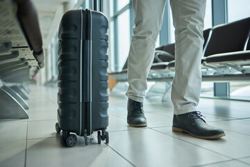 Canvas Print - Airport, suitcase and person legs for travel, international opportunity or global journey walking in lobby. Luggage, bag and entrepreneur shoes or business man feet on vacation flight or hospitality