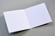 Laying blank open empty square greeting card mock up on grey background. For use as a Christmas, birthday, wedding or celebration background template.	
