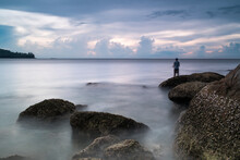 Man Fishing On Rocks Near Kamala Beach, Phuket Province, Thailand