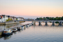 Meuse River With Bridge, Boats And Buildings On Bank, Maastricht, Limburg, Netherlands