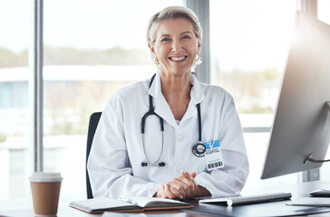 Poster - Healthcare, medicine and portrait of a doctor at a desk for medical work, cardiology and surgery. Happy, working and mature woman consulting in medicare, hospital research and expert consultation