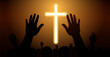 © puttipong - People raise their hands in front of the cross to pray. Many people worship God.