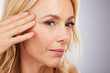 © Nina L/peopleimages.com - Face, skincare and antiaging with a mature woman in studio on a gray background for natural beauty. Hand, wellness and facial with a senior female touching her skin for luxury cosmetic treatment