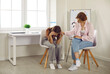 © Studio Romantic - Teenage problems. Female school psychologist supporting sad teenage girl during her difficult situation at school. Female psychologist touches shoulder of teenage girl who sadly bowed her head.
