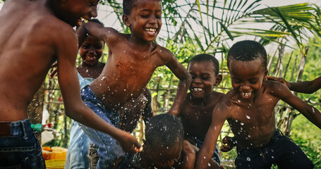 Wall Mural - A Group Of African Children, Laughing, Jumping And Playing in Rural Area. Black Kids Celebrating Life with Joy. Camera Captures Beauty and Essence Of Childhood, Innocence and Purity of Live in Village