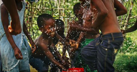 Wall Mural - A Group Of African Children, Laughing and Playing with Water in Rural Area. Black Kids Celebrating Life with Joy. Camera Captures Beauty Of Childhood, Innocence and Purity of Live in Village