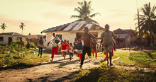 Group Of African Little Children Running Towards The Camera And Laughing In Rural Village. Black Kids Full Of Life And Joy Enjoying Their Childhood And Playing Together. Little Faces With Big Smiles