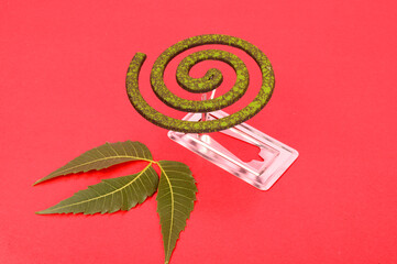 Mosquito coil is mosquito-repelling incense, made by (Azadirachta indica), neem leaves, usually shaped into a spiral, Anti mosquito, green color - insecticides. with neem leaves isolated