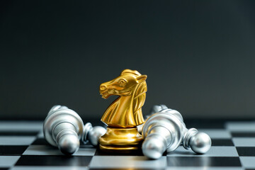 Wall Mural - Gold horse knight in chess game with the lying silver team on black background (Concept for company strategy, business victory or decision)