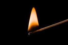 Lone Burning Match With The Flame  Isolated On Black Background