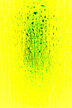 Water Drops In Green And Yellow On Glass With Detail Background