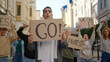 © RZ Images - Public demonstration at city street with hispanic man in front of multiracial protesting people