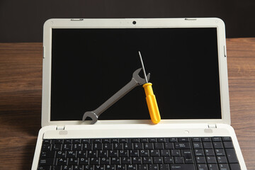 Wall Mural - Wrench and screwdriver with a laptop computer. IT Service. Support