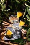 Fototapeta Uliczki - Champagne cocktail with pineapple decoration on a rattan table