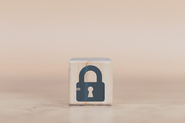 cyber security wood cube concept, man's hand laying down a wood cube with a padlock icon, to convey protection. Cyber ​​security with danger to data and assets