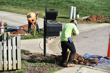 Utility workers dig up yards in preparation for fiber optic internet. 