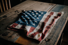 Vintage American Flag Lays Spread Out On Wooden Table, Edges Slightly Frayed And Tattered From Years Of Use. Red And White Stripes Are Faded, And Blue Field With White Stars Has A Slightly Muted Hue.