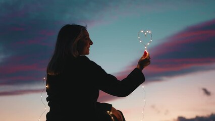 Wall Mural - silhouette of Girl with Heart symbol in the sky