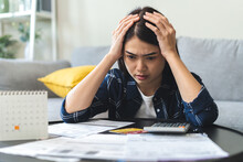 Business Financial Concept, Owe Asian Young Woman, Female Sitting Expression Face Stressed By Calculate Expense On Table From Invoice Or Bill, Have No Money To Pay Mortgage Or Loan. Debt, Bankruptcy.