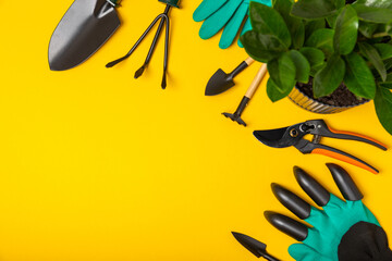 Wall Mural - Gardening tools, pruner, gardening gloves, shovel and rake on a bright yellow background. Garden conceptual composition.Place for text. Place for copying. Gardening and hobby concept.gardening tools