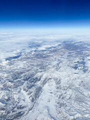Wall Mural - aerial view of snow-covered mountains and valleys of Caucasus from airplane