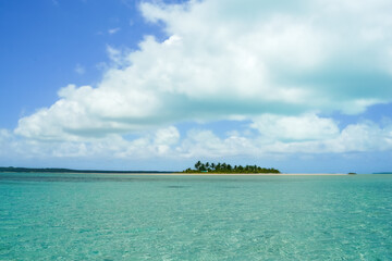 Wall Mural - Typical tropical South Pacific scene heat haze over turquoise water, low atoll island on horizon blue sky and white clouds