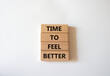 Time to feel better symbol. Wooden blocks with words Time to feel better. Beautiful white background. Medicine and Time to feel better concept. Copy space.