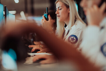 Wall Mural - Group of Security data center operators working in a CCTV monitoring room looking on multiple monitors.Officers Monitoring Multiple Screens for Suspicious Activities