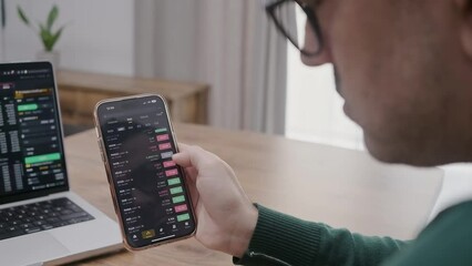 Poster - businessman in eye glasses analysing stock market charts on laptop and smartphone screen. Bitcoin and crypto currency investment concept.
