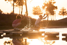 Children Playing At Water Park On A Hot Summer Sunset Day
