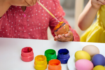 Wall Mural - Two girls paint Easter eggs for holiday at home