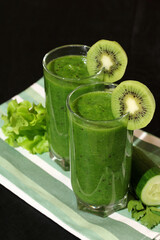 glasses of smoothies made of raw cucumbers, kiwi and lettuce leaves. green vitamin drink.