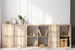 Wooden chest of drawers with books and decor near light wall