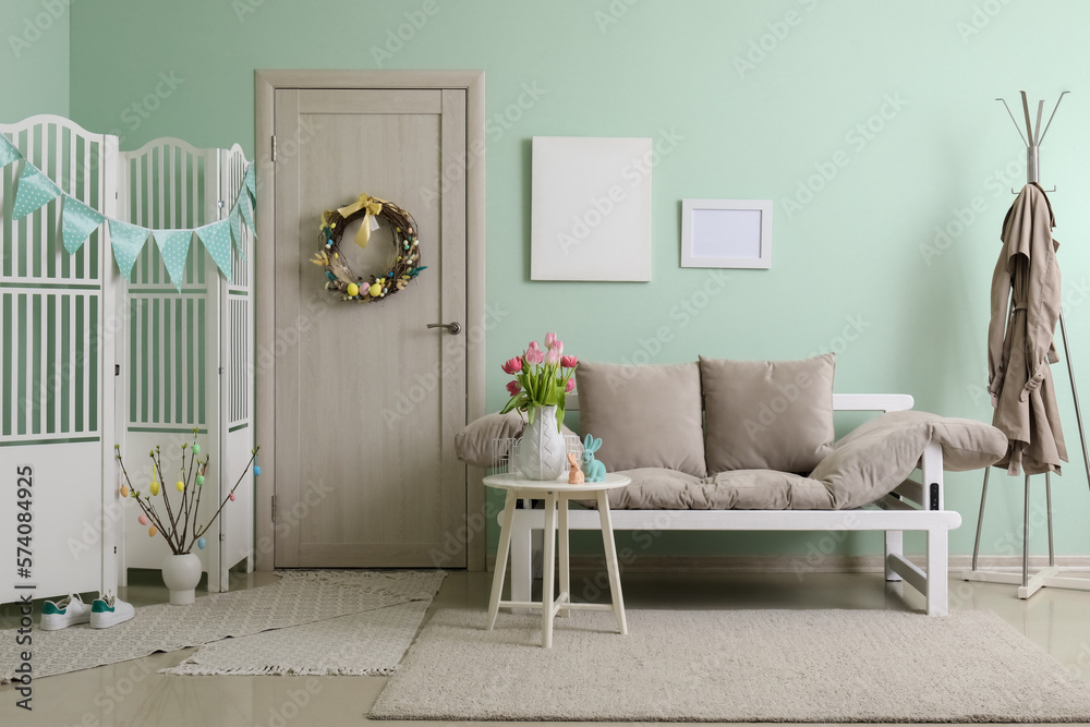 Vase with tulips and Easter bunnies on end table in living room