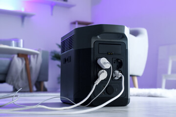 Portable power station charging devices on floor in living room