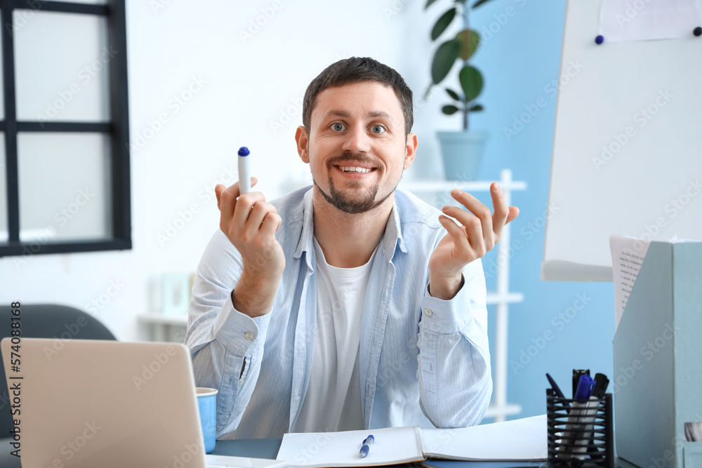 Male tutor with marker giving online lesson at home