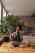© Kostiantyn - Professional woman florist examines seedlings in floral studio. Gardening concept