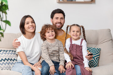 Canvas Print - Happy family watching TV on sofa indoors