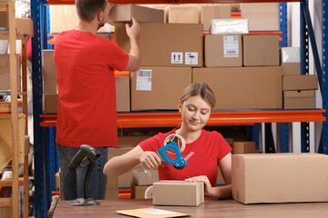 Canvas Print - Post office worker packing parcel at counter indoors