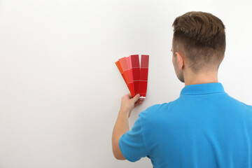 Poster - Man with palette choosing color for painting wall indoors. Interior design