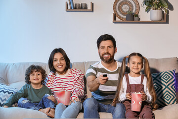 Canvas Print - Happy family watching TV with popcorn on sofa indoors