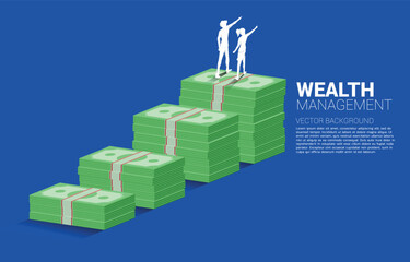 Silhouette of businessman and businesswoman standing point ahead on top of growth graph with stack of banknote. Concept of success investment and growth in business