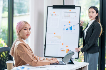 Wall Mural - Businesswoman explaining marketing statistics to executive manager working together at company strategy during business meeting in startup office. Businesswoman planning partnership project