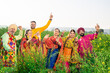 Punjabi sikh family doing bhangra dance in agriculture field celebrating Baisakhi or vaisakhi festival.