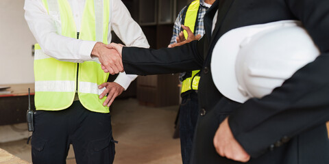 Wall Mural - Civil Construction team Handshake at renovate construction site. architectural plan, engineer sketching a construction project, green energy concept.