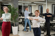 © Михаил Решетников - Four office workers warm up during a break. Employees do fitness exercises at the workplace.